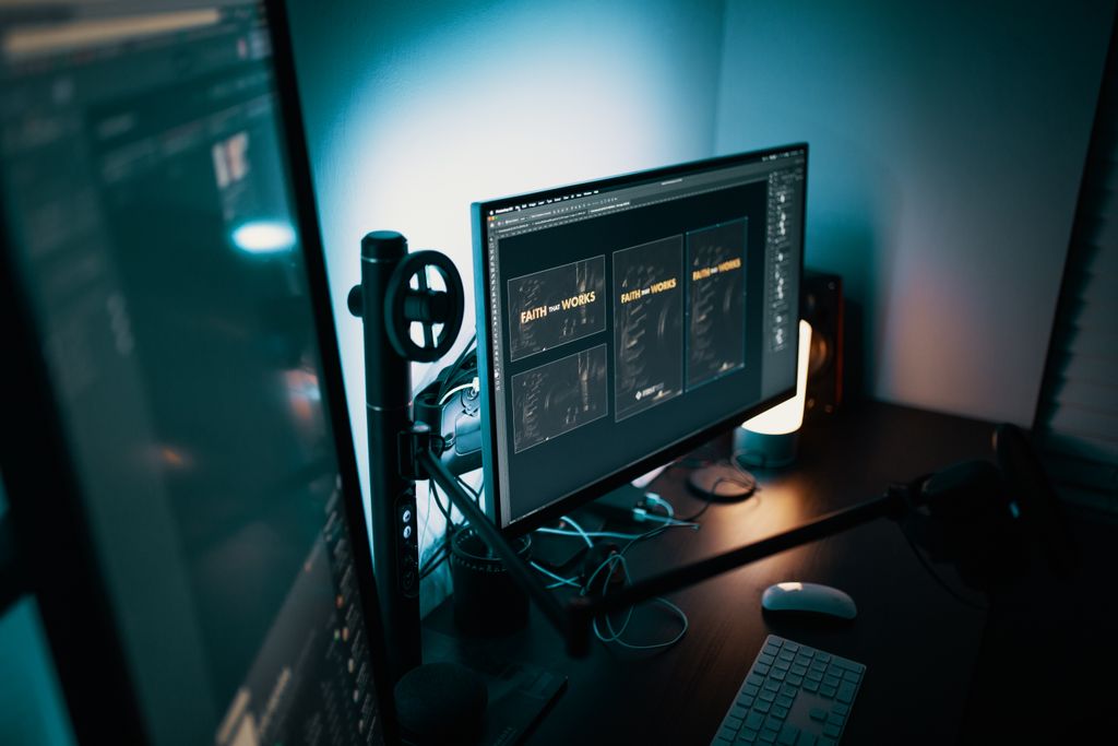 A stylish modern workspace with dual monitors displaying design software in a dimly lit room.